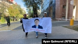 Активистки с баннером с призывом к властям Казахстана освободить Жанболата Мамая. Алматы, 6 октября 2022 года