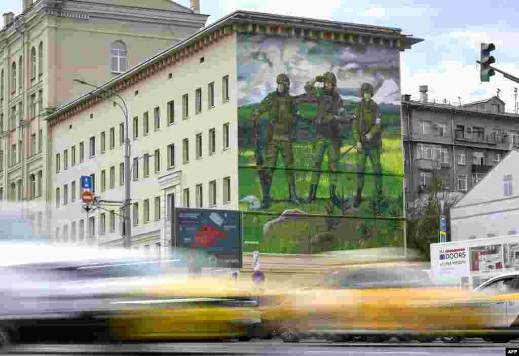 Автомобили в Москве проезжают мимо мурала с изображением российских солдат с символом «Z» на униформах, который используется как провоенная эмблема вторжения России в Украину. Москва, РФ, 12 октября 2022 года