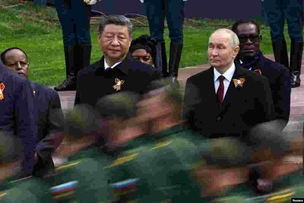 Президент России Владимир Путин и председатель КНР Си Цзиньпин наблюдают за прохождением российских военнослужащих во время церемонии возложения цветов к Могиле Неизвестного Солдата в День Победы, Москва, Россия, 9 мая 2025 года. REUTERS/Evgenia Novozhenina 