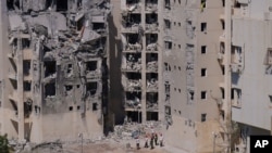 Inspectorii oficiali și voluntarii israelieni verifică miercuri, 25 iunie, o clădire rezidențială avariată în ceea ce a fost poate ultimul atac cu rachetă dinspre Iran, la Beersheba.