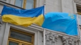 «Два флага – одна страна». Украинский государственный и крымскотатарский национальный флаги на флагштоках перед зданием МИД Украины в Киеве