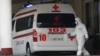 Armenia -- A medical worker clad in protecive gear and an ambulance parked at the entrance to Surp Grigor Lusavorich hospital, Yerevan, April 8, 2020.